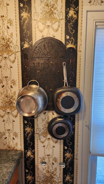 The headstone/printing plate/pegboard in place in the residency kitchen wall, it goes rather nicely with the ornate gothy wallpaper